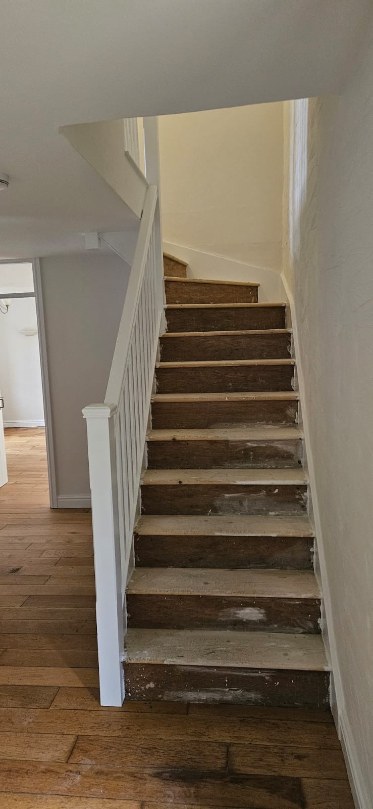 Hallway with staircase and wood flooring throughout